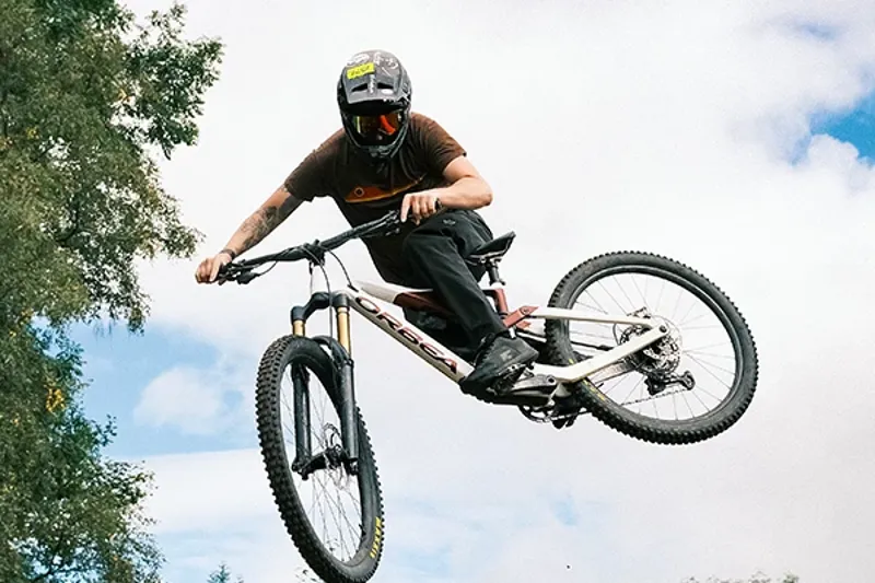 mtbb rider sending a jump with full face helmet and goggles