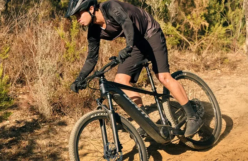 Rider tackling an off-road trail on a Giant Fathom E+ electric mountain bike