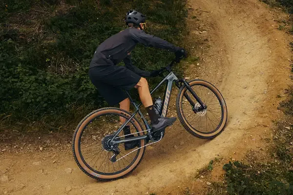 Rider climbing a trail on a Giant Talon E+ hardtail electric mountain bike