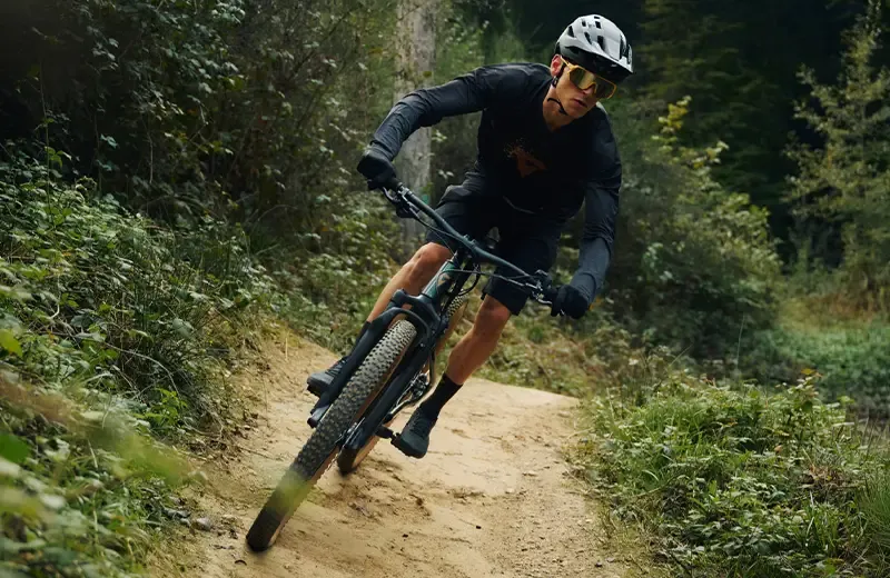 Rider cornering on a trail aboard a Giant Talon E+ electric mountain bike