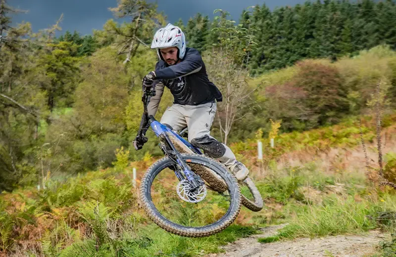 Mike Jones cornering on a Giant Trance Advanced E+ on a wooded trail