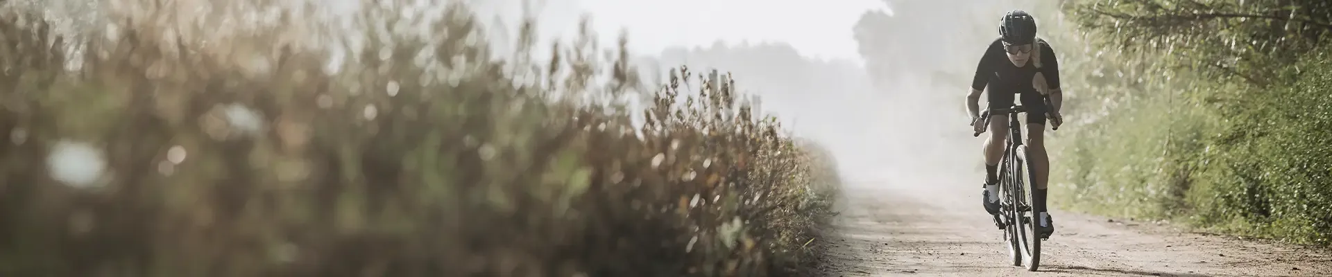 Female gravel bike rider exploring a dusty gravel road