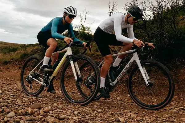 Two gravel bike riders on a loose pebbly track