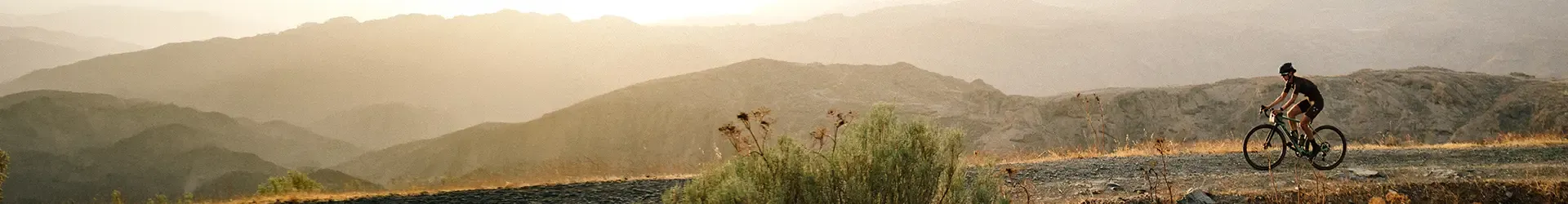 Gravel bike rider on a wide open mixed terrain route in the hills