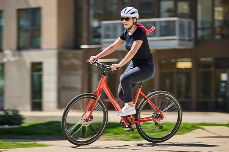 Woman riding an upright hybrid bike on a summer day in the city