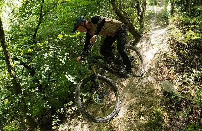 Chris Akrigg descending a steep technical woodland trail on a Whyte Karve RSX