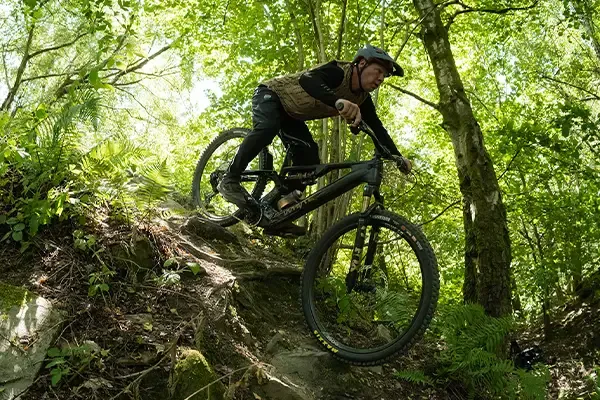 Chris Akrigg descending a technical woodland trail on a Whyte Karve RSX