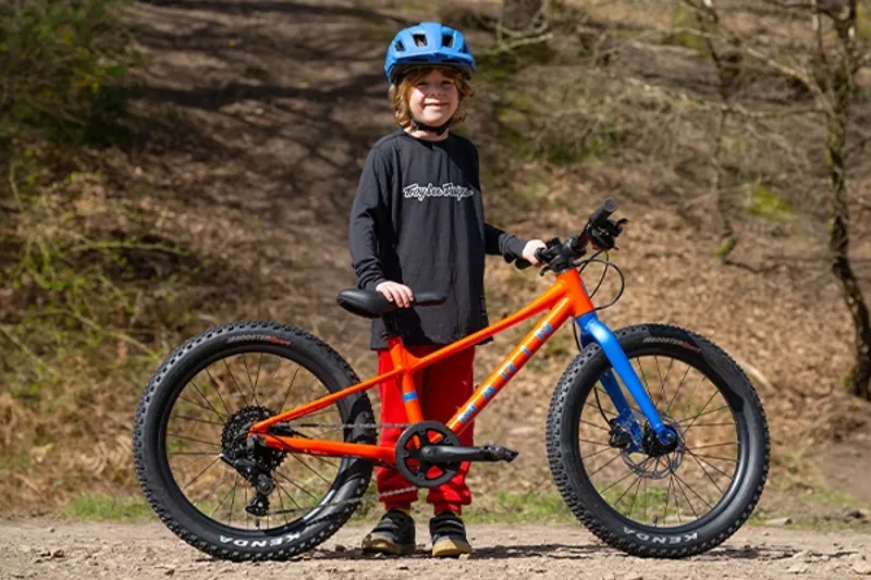 Child standing next to his correctly sized Marin Bear Valley kids bike