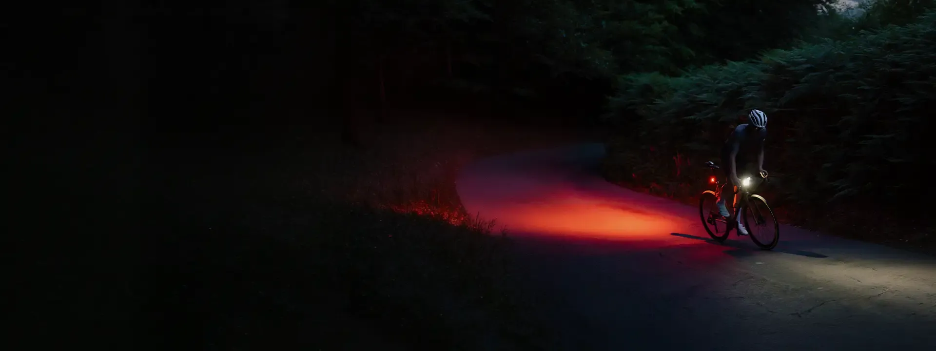Cyclist riding at night with bike lights illuminating the road