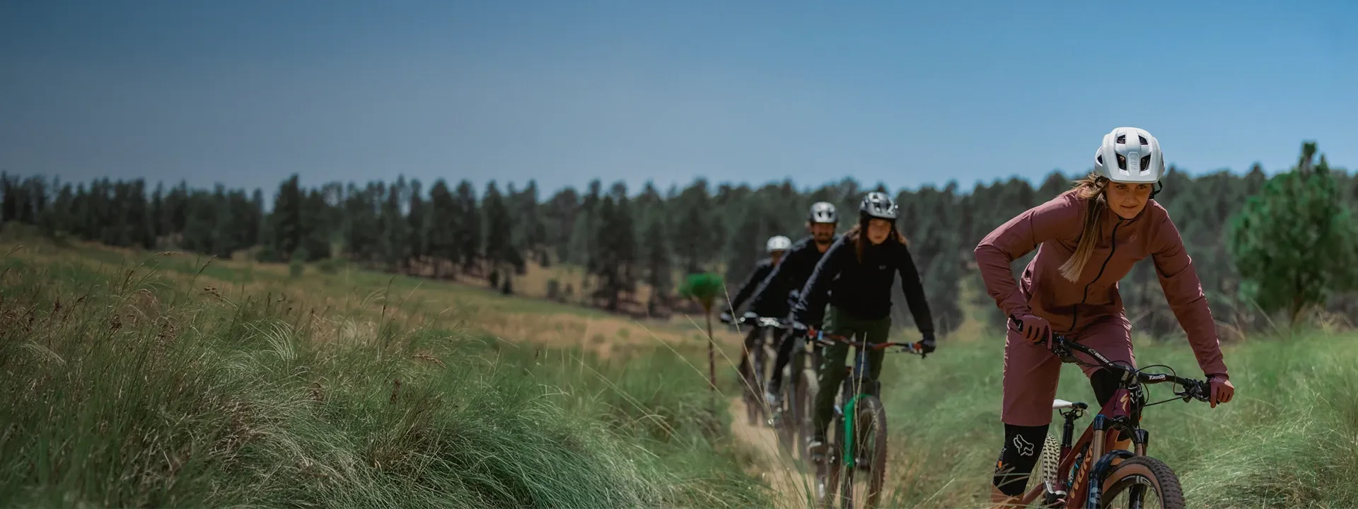 Mountain biker riding in light rain wearing a showerproof MTB jacket