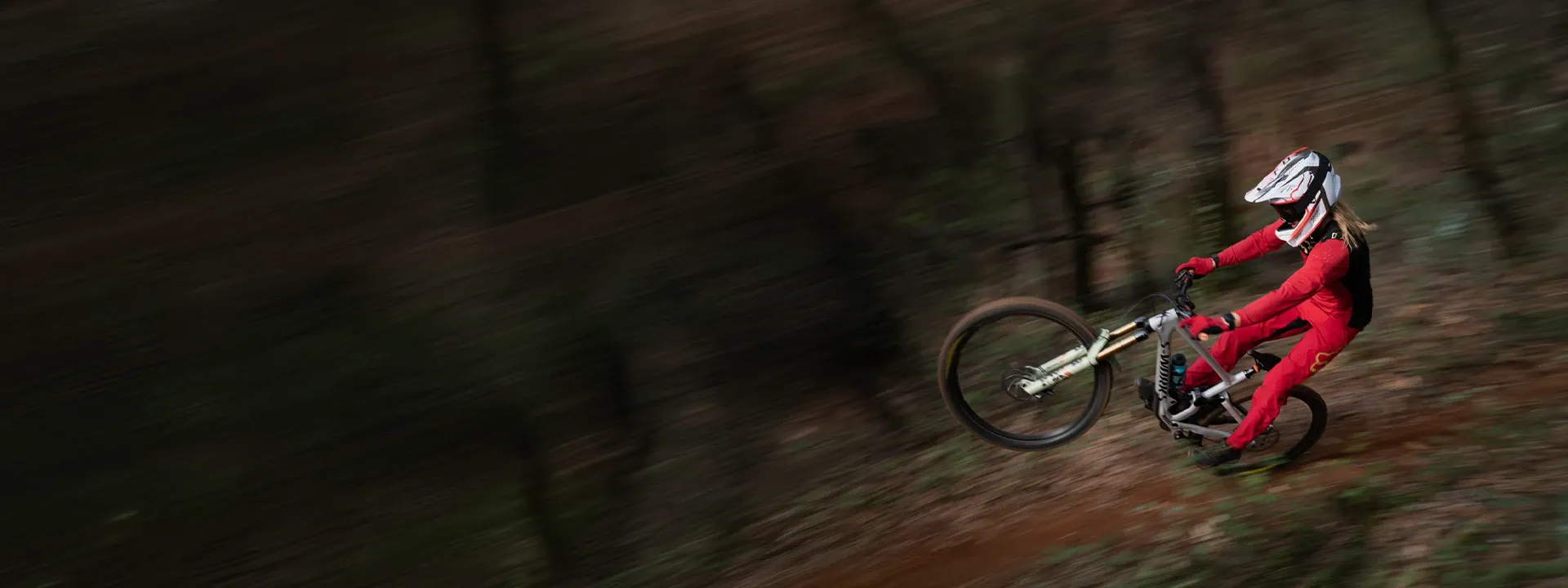 Mountain biker wearing a long sleeve jersey on a forest trail ride