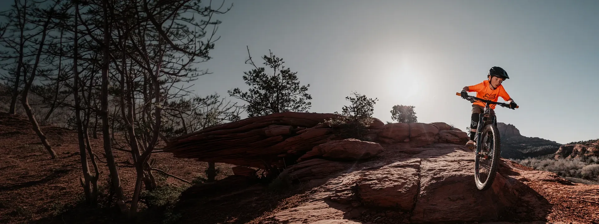 Kids riding mountain bikes on a trail wearing MTB clothing
