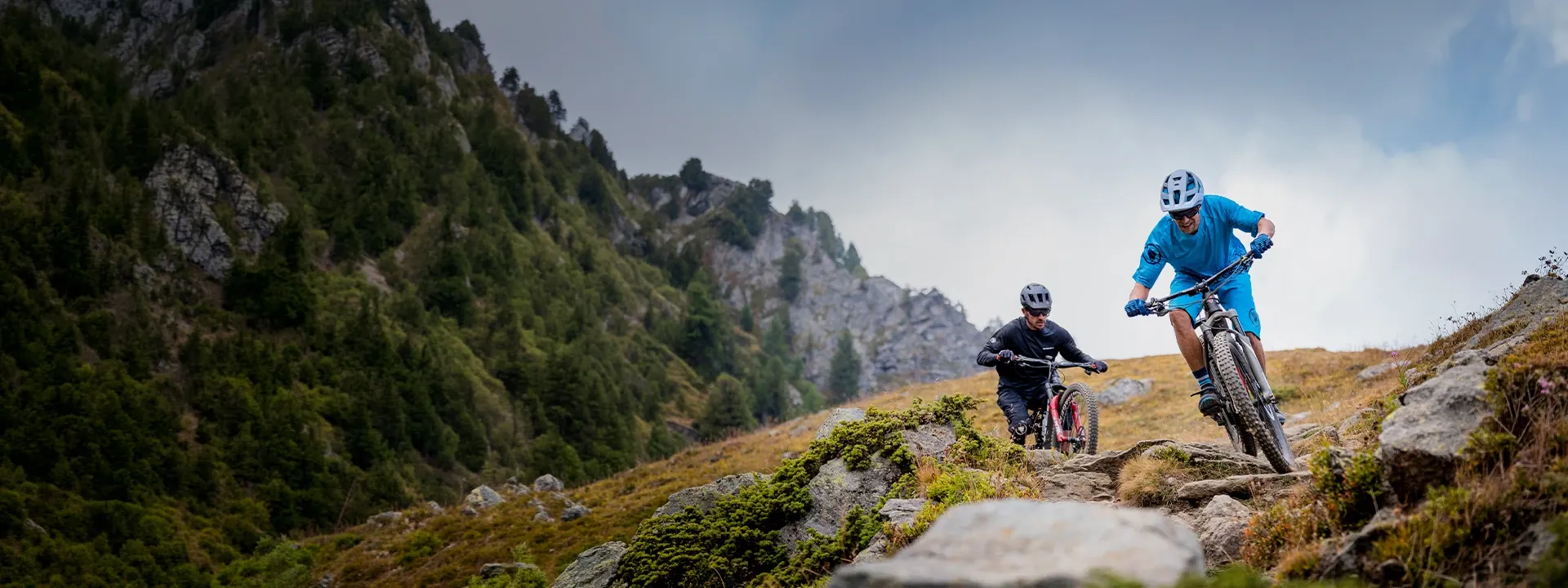 Male mountain biker riding on a trail wearing MTB clothing