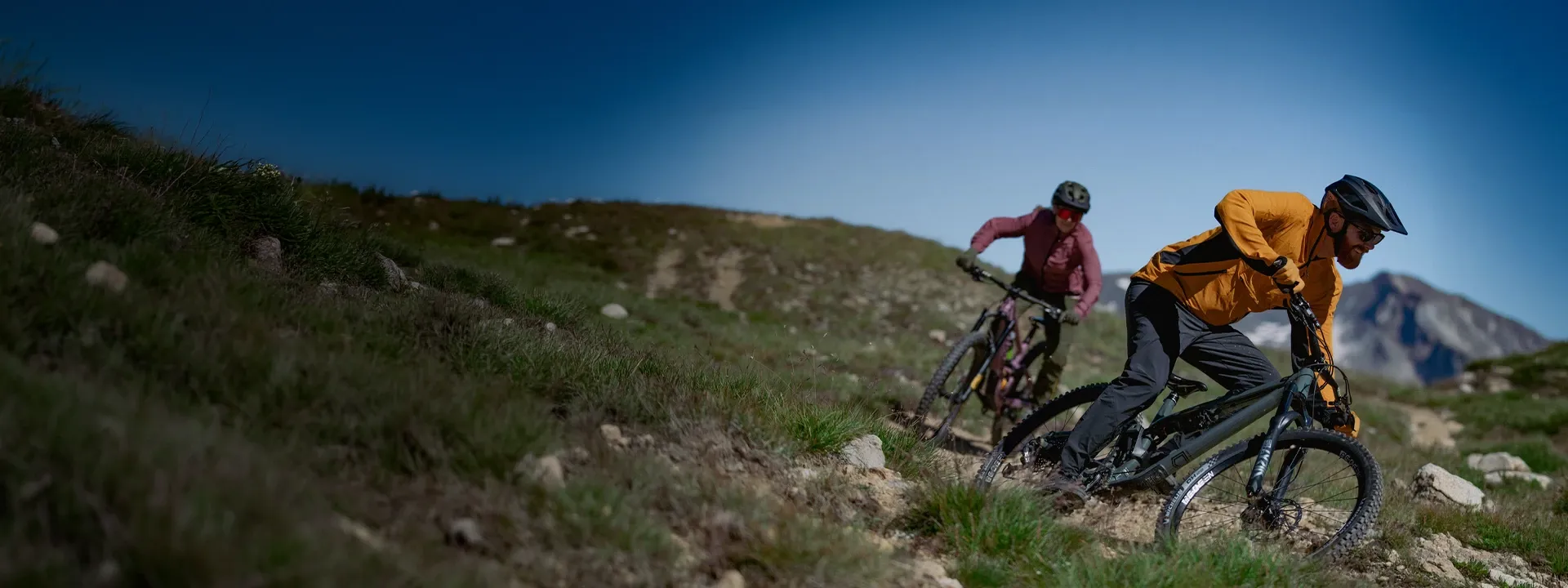Mountain biker wearing high-performance MTB jersey and jacket on a trail ride