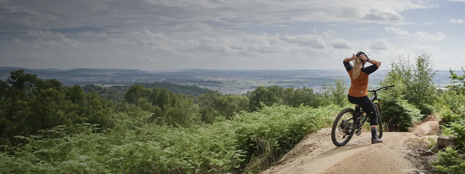 Female mountain biker riding on a trail wearing MTB clothing