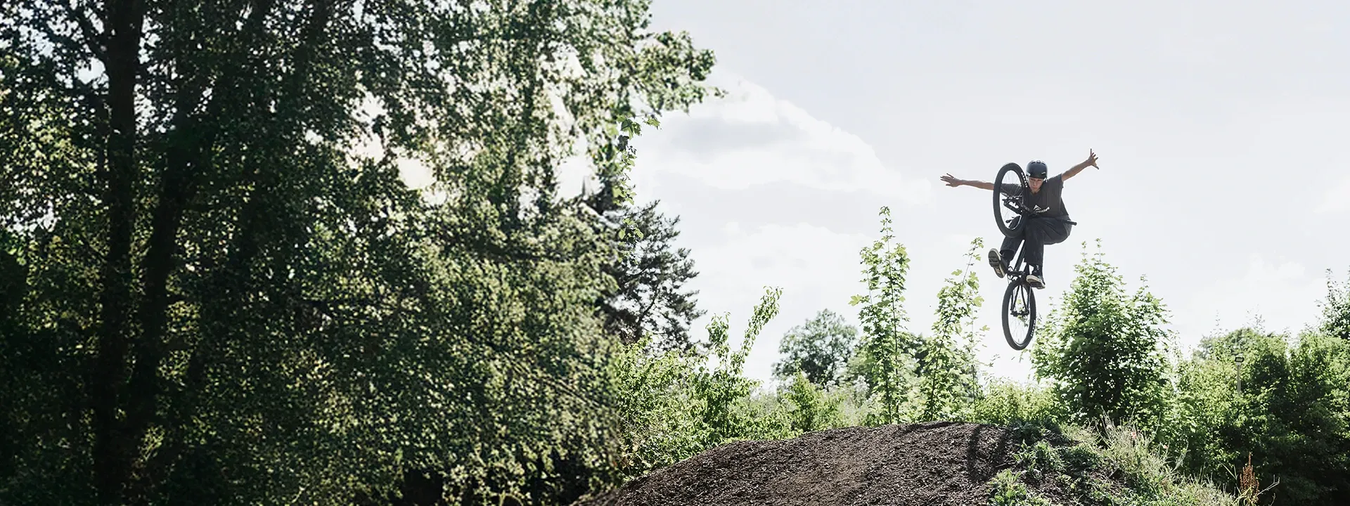 Dirt jump mountain bike in the air over a jump