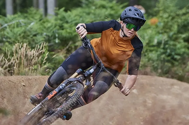 Female mountain biker wearing a short sleeve MTB jersey on trail