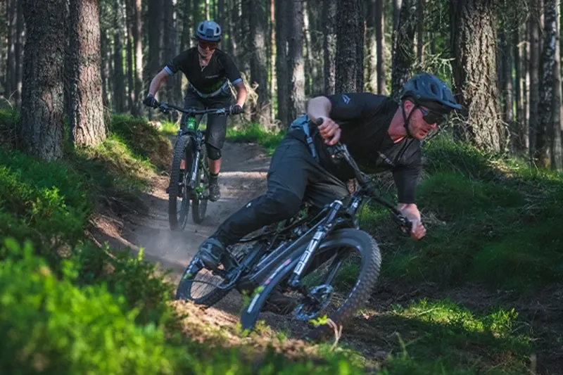 Mountain bikers riding Merida trail bikes in the woods with confidence