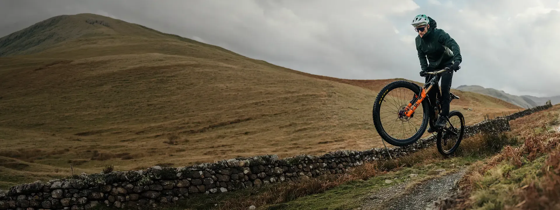 Mountain biker riding a wet trail with a front mudguard fitted