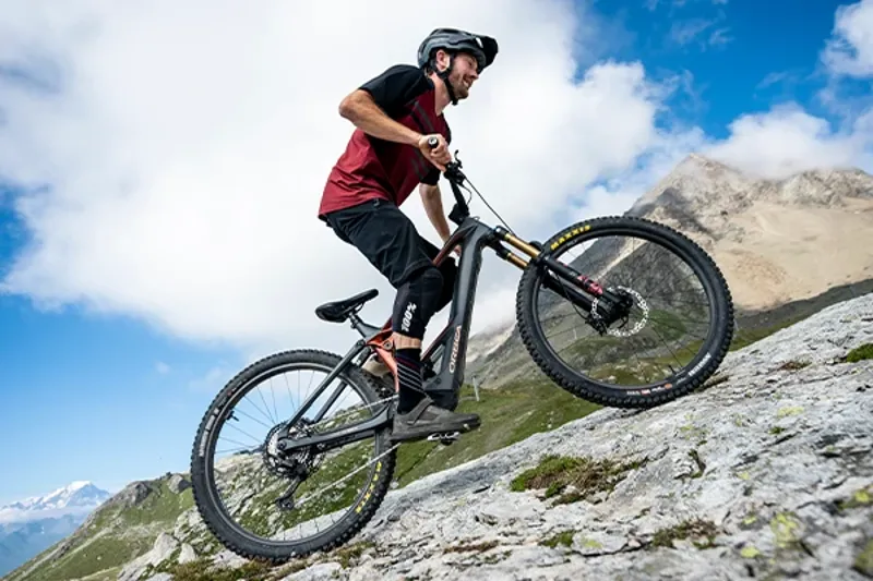 Rider climbing a steep mountain trail on an Orbea Wild eMTB