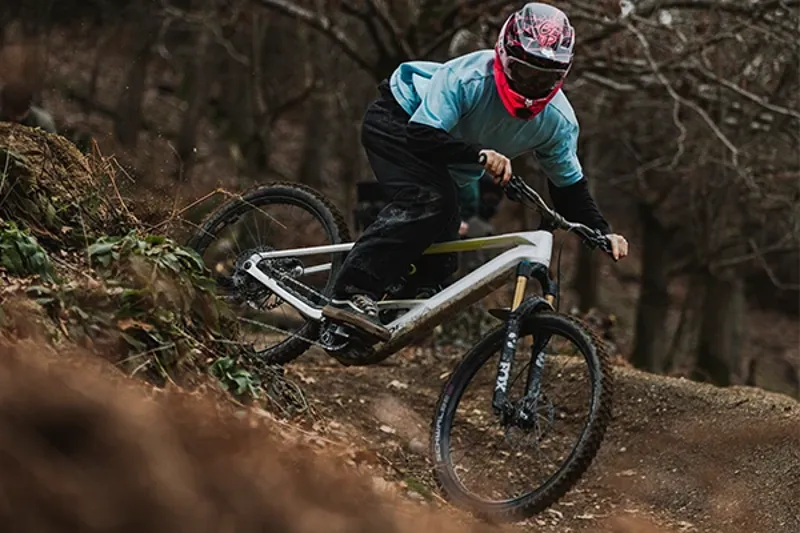 Rider descending a steep downhill trail on an Orbea Wild electric mountain bike