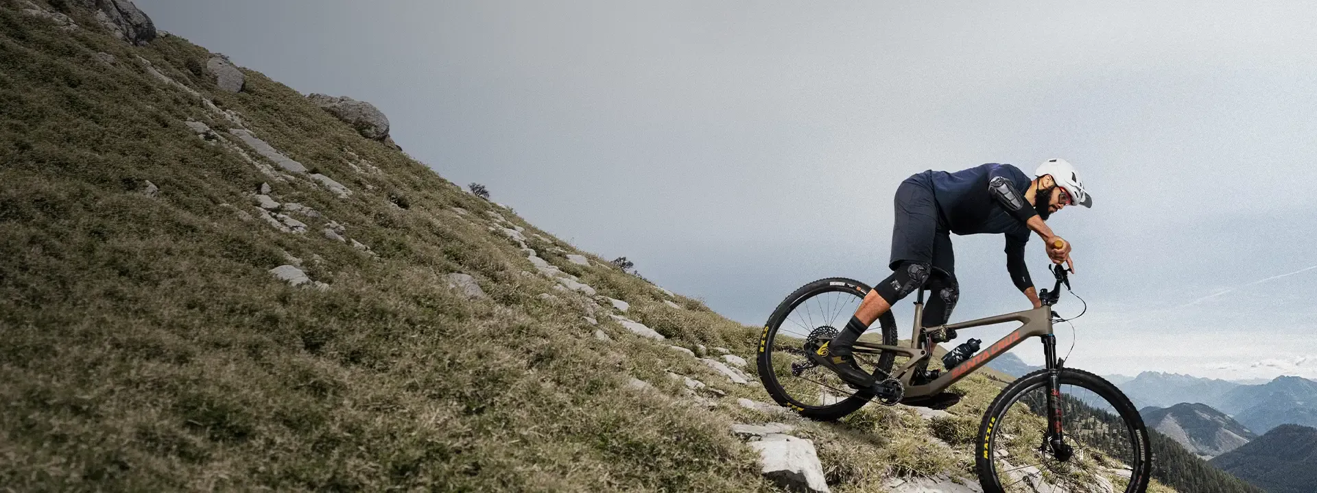 Mountain biker wearing elbow pads on a technical trail