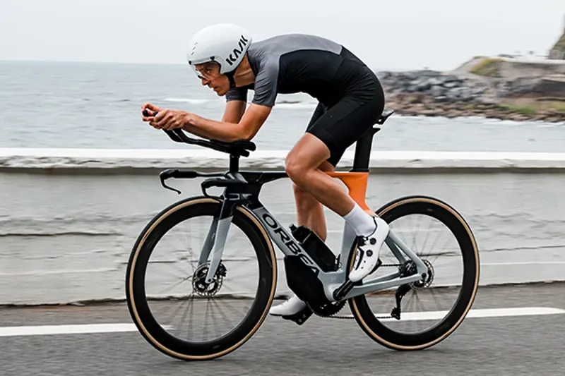 Riding an Orbea Triathlon bike on a coast road