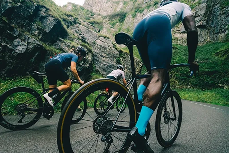 Group of riders wearing road cycling bib shorts showing close fit in riding position