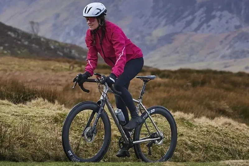 Woman riding in the hills wearing a Madison waterproof road cycling jacket