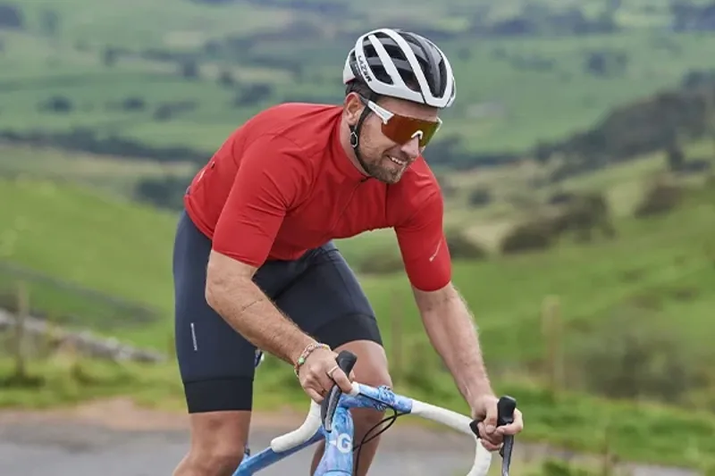 Rider wearing a short sleeve road cycling jersey on the bike.