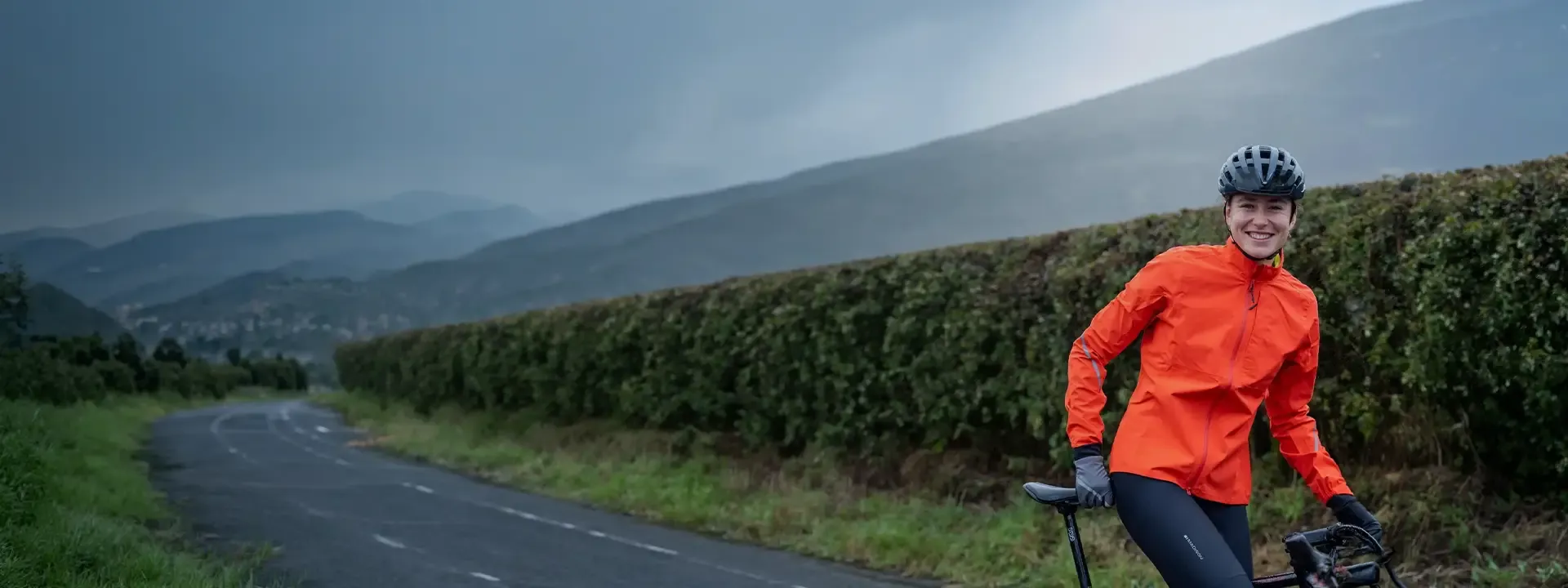 Road cyclist riding in heavy rain wearing a waterproof road bike jacket