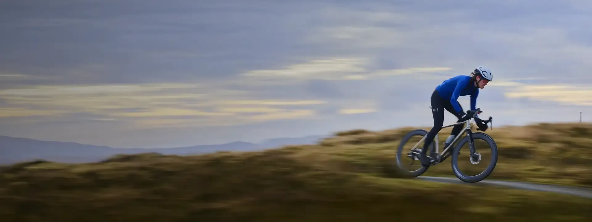 Road cyclist wearing a lightweight windproof jacket on a cool descent