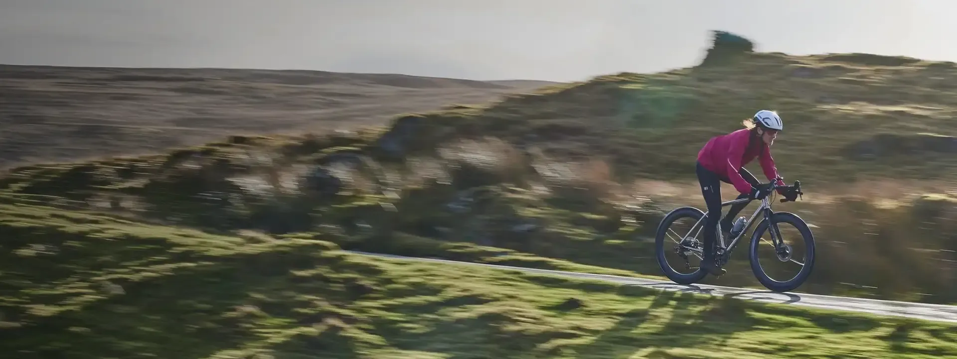 Road cyclist wearing a protective jacket riding in wet and windy conditions