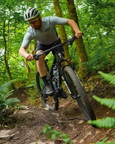Riding the Specialized Epic 9 on a tight technical turn in the woods