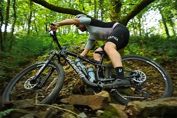 Riding the Specialized Epic 9 on a rocky woodland trail