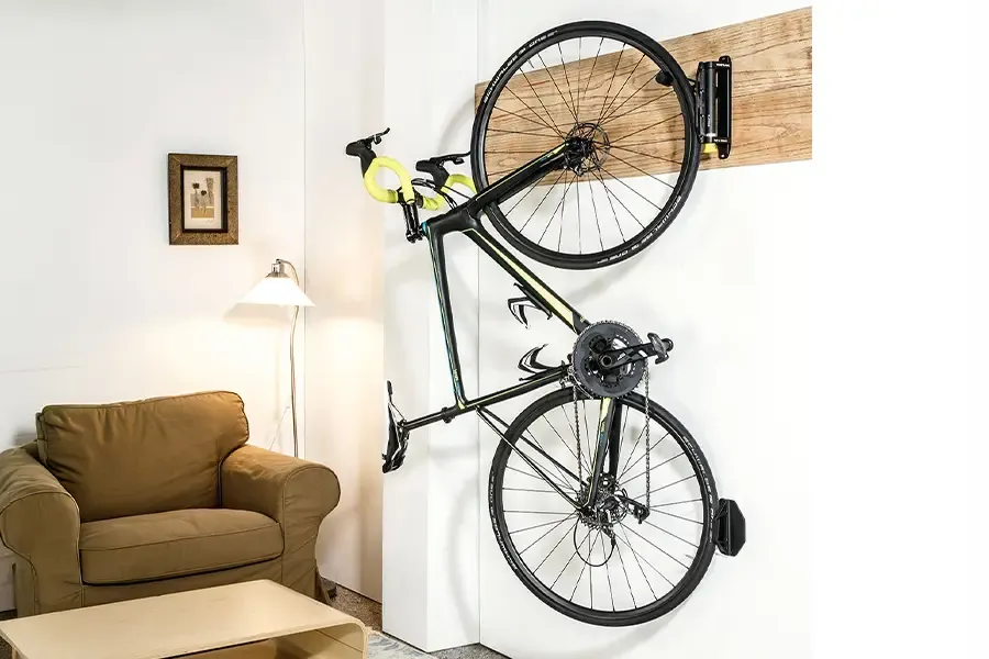 road bike hanging from a storage hook in a living room