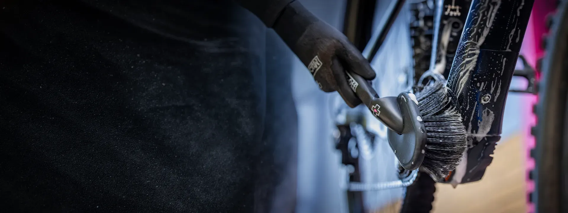A bicycle drivetrain being cleaned with a brush
